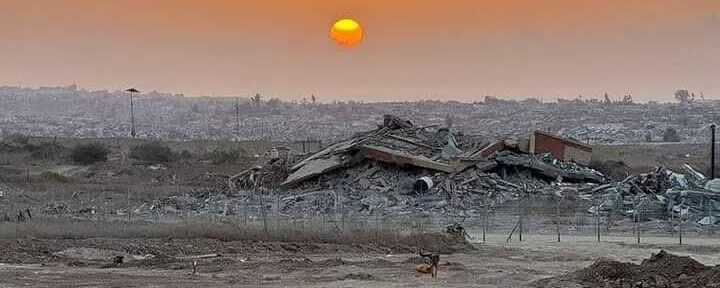 Sunset over a pile of concrete rubble and destroyed buildings in Gaza.